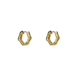 Vue détaillée des boucles d'oreilles cœur dorées avec texture métallique irrégulière chic
