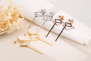 Macro shot of geometric long dangle earrings in gold, silver and rose gold finishes