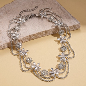 Macro detail of luxury floral rhinestone choker necklace layered on a natural stone base