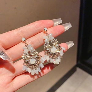 Detail view of vintage flower earrings with white beads and sparkling rhinestones