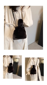 Détail du sac seau en peluche noire montrant la texture douce et les options de style