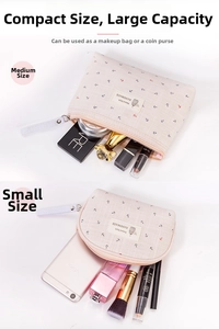 Detail view of two canvas cosmetic bags with anchor patterns in medium and small sizes