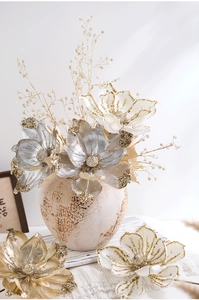 Close-up of elegant champagne gold magnolia flowers and vintage textured ceramic vase
