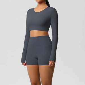 Detail van antracietgrijze crop top met lange mouwen en yoga shorts met hoge taille