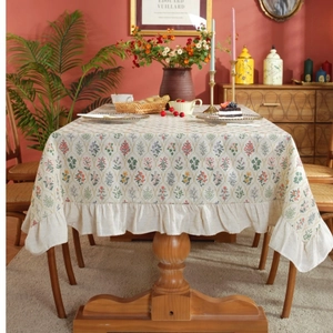Floral rectangle tablecloth with ruffles on a wooden dining table for home decor