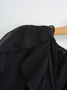 Close-up of ruffled shoulder detail on a black chiffon shirt for women on a hanger