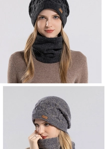 Detailed cable knit texture and brown leather brand patch on the winter hat and scarf set