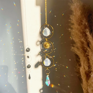 Detail of hanging crystal suncatcher showing golden sun pendant and light refraction