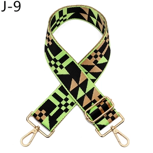 Close-up of geometric woven shoulder strap with green pattern and gold metal hooks