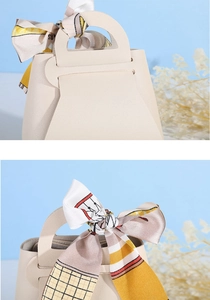 Detail of cream leather wedding candy box with elegant plaid scarf and buckle handle