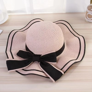 Macro detail of pink sun hat featuring a delicate wave edge and black bow decoration