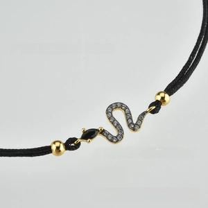 Close-up of snake charm bracelet with black stones and sparkling crystal pavé details