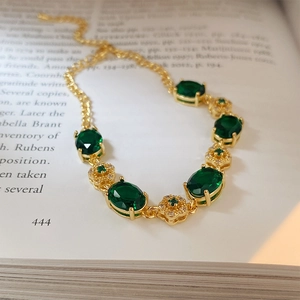 Macro detail of emerald flower bracelet with gold plating on vintage book pages