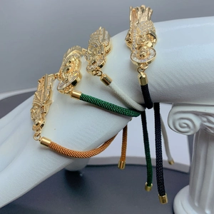 Detail of adjustable woven religious bracelets with gold St. Jude pendants and zircon crystals