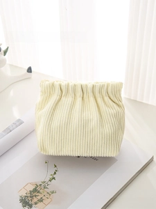 Detail of light yellow corduroy cosmetic bag showing soft vertical ribbed texture and pouch