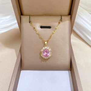 Elegant gold titanium necklace featuring a large pink oval gemstone with zircon border