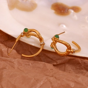 Macro view of vintage 18K gold plated lava hoop earrings with green stones and zircons