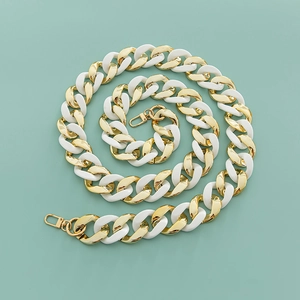 Detail of chunky white resin and gold metal chain link bag strap with lobster clasps