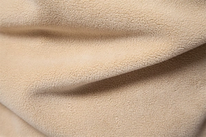Macro detail of soft beige fleece fabric showing warm texture and high-quality fibers