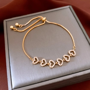Detail of 6 hollow heart charms with cubic zirconia on a gold box chain with bolo clasp