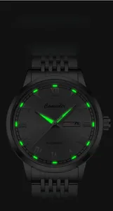 Detail of Comudir automatic watch featuring glowing luminous markers and date display