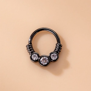 Macro shot of black nose ring with three clear zircons and spiral texture detail
