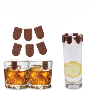 Brown silicone glass markers with letter embossing on a whiskey glass for party sorting