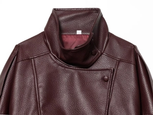 Détails du col montant et des coutures d'épaule d'une veste en similicuir bordeaux