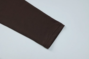 Detail of coffee brown pleated sleeve cuff with fine knit texture and stitching