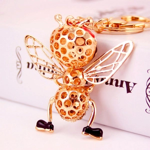 Golden hollow metal bee keychain with ornate wings and spring clasp for bag accessory