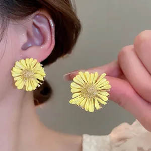 Yellow raffia daisy stud earrings for women shown on model for seaside vacation style