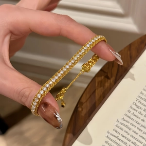 Detail view of the gold-plated snake chain bracelet featuring sparkling zircon stones
