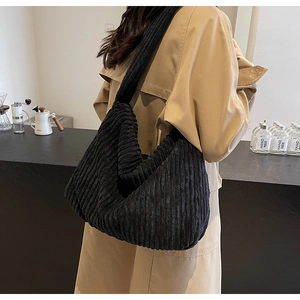 Detailed texture of black corduroy hobo bag on model in a casual lifestyle setting