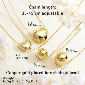 Detail view of heart and sphere pendant necklaces with size dimensions in copper gold plating