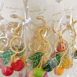 Detailed view of colorful cherry keychains with rhinestones and gold metal D-ring clasps