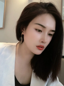 Detail of elegant black enamel teardrop earrings with gold-plated brass on a female model