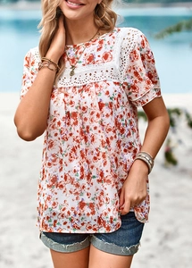 Detailed view of floral chiffon top with white lace patchwork and vibrant red flower print