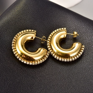 Close-up of 18K gold plated hoop earrings with zircon border on black leather base