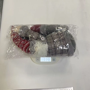 Detailed view of plush Christmas gnome curtain buckle being weighed for product specifications