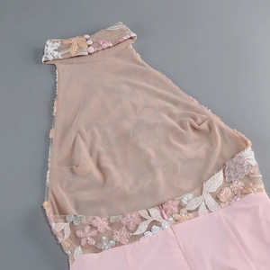 Dettaglio del ricamo rosa e paillettes sul corpetto dell'abito in rete a lupetto