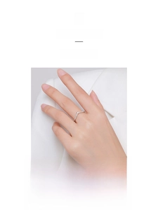 Close-up of a delicate rose gold V-shaped chevron ring with micro-pave white zircons