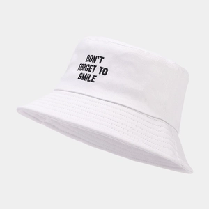 Close-up of white cotton bucket hat featuring black Don't Forget To Smile embroidery