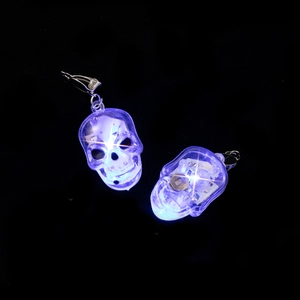 Detail of LED light-up skull earrings showing internal circuitry and blue glow