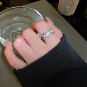 Detail of luxury emerald cut zircon ring with micro-pave setting on a female hand