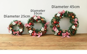 Three sizes of Christmas wreaths with pine needles and cones on a wooden table