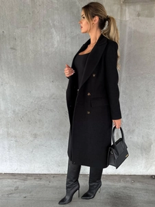Detail of a black wool coat with double-breasted buttons and lapel collar in street style