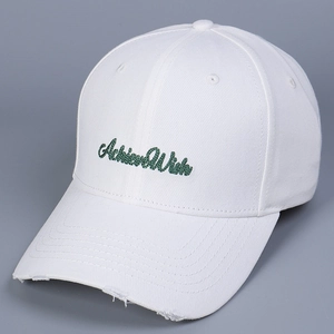 Detail of white cotton baseball cap showing AchieveWish embroidery and distressed brim edge