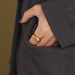 Polished minimalist gold dome ring for women shown on a model's hand in a suit pocket