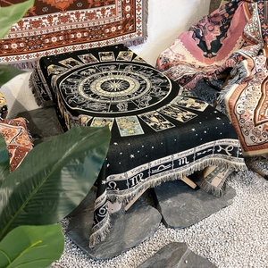 Detail of bohemian woven blanket with zodiac tarot patterns and fringe tassels