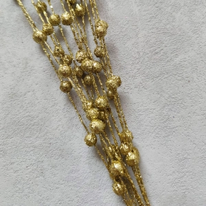 Macro shot of gold glitter Christmas berry picks with sparkling sequin foam balls